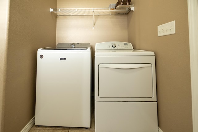 washroom with washer and clothes dryer and light tile patterned flooring