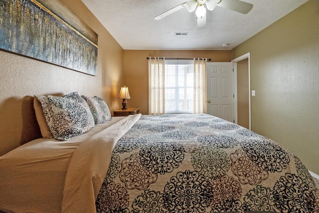 bedroom featuring ceiling fan and a textured ceiling