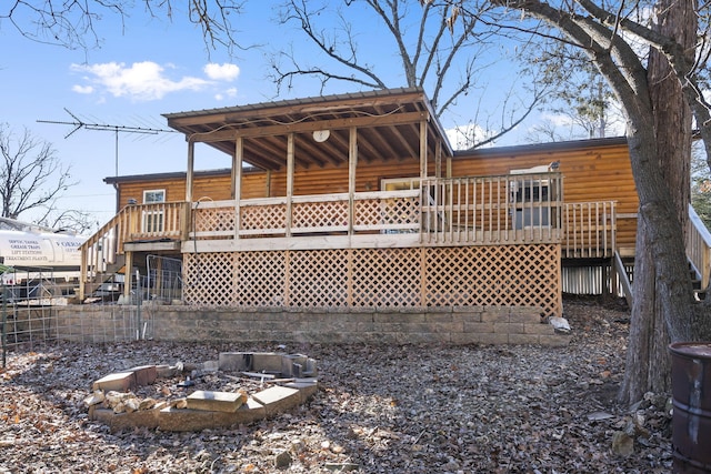 back of property featuring a wooden deck and an outdoor fire pit