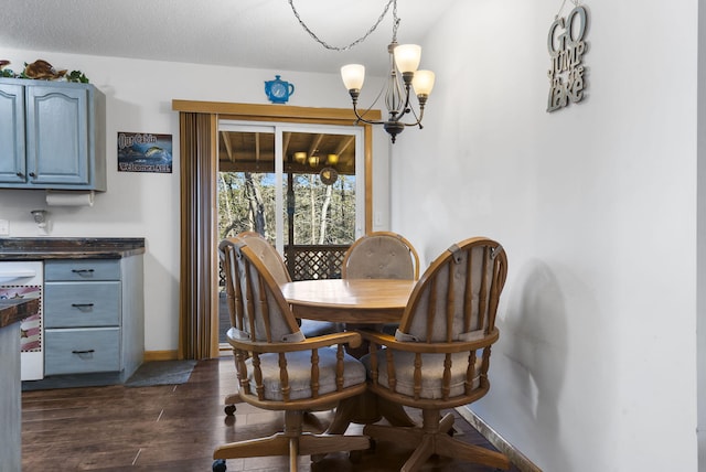 dining room featuring dark hardwood / wood-style floors, a textured ceiling, and an inviting chandelier