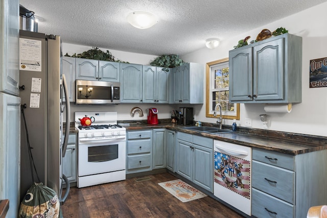 kitchen featuring dark hardwood / wood-style floors, appliances with stainless steel finishes, sink, and a textured ceiling