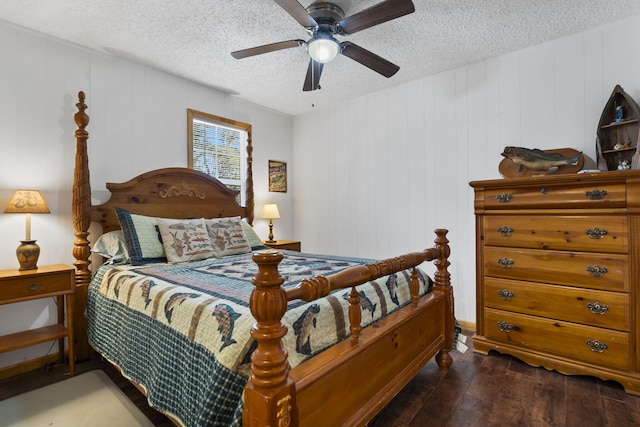 bedroom featuring dark wood-type flooring, ceiling fan, a textured ceiling, and wood walls