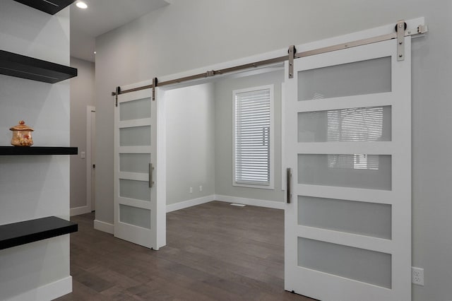 interior space featuring a barn door and dark hardwood / wood-style floors