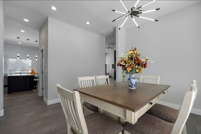 dining room featuring dark wood-type flooring, a chandelier, and sink