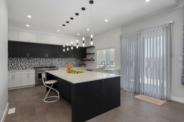 kitchen featuring pendant lighting, sink, dark hardwood / wood-style flooring, double oven range, and a center island