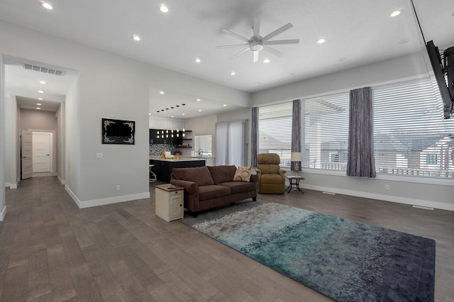 living room with ceiling fan, indoor bar, and dark hardwood / wood-style flooring