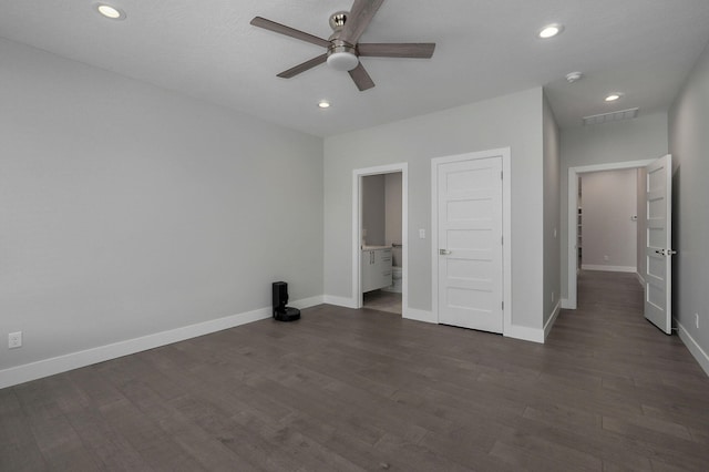 unfurnished bedroom featuring dark wood-type flooring, connected bathroom, and ceiling fan