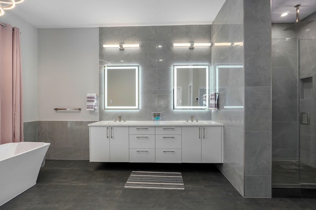 bathroom with vanity, separate shower and tub, and tile walls