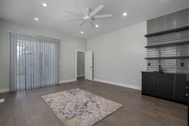 living room featuring dark wood-type flooring and ceiling fan