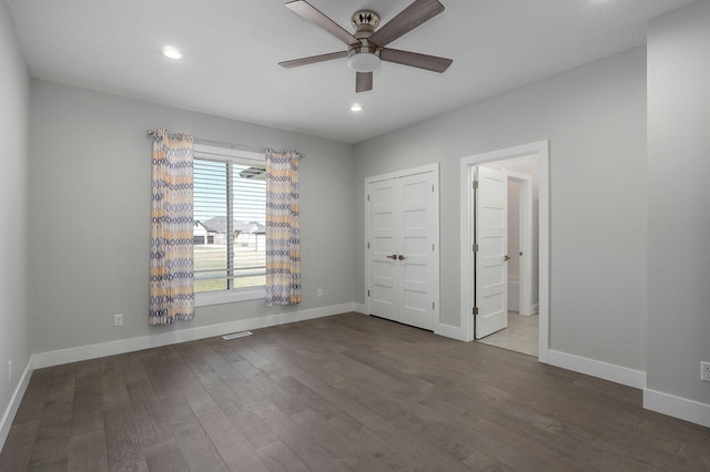 unfurnished bedroom featuring ceiling fan and dark hardwood / wood-style flooring