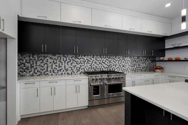 kitchen with tasteful backsplash, white cabinets, dark hardwood / wood-style flooring, decorative light fixtures, and range with two ovens