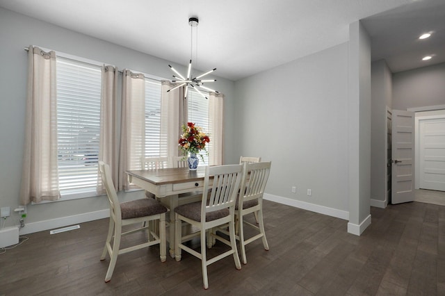 dining space with plenty of natural light, dark hardwood / wood-style floors, and a chandelier