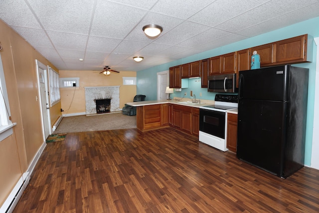 kitchen featuring sink, black fridge, dark hardwood / wood-style floors, kitchen peninsula, and range with electric cooktop