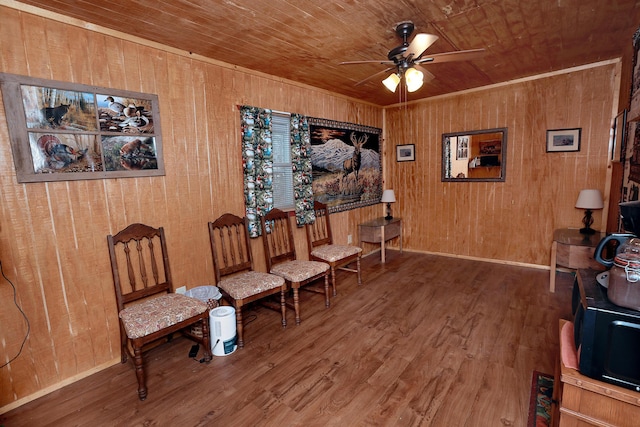 living area with wood ceiling, wood walls, ceiling fan, and hardwood / wood-style flooring