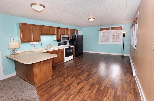 kitchen with range with electric stovetop, dark hardwood / wood-style floors, sink, kitchen peninsula, and black fridge