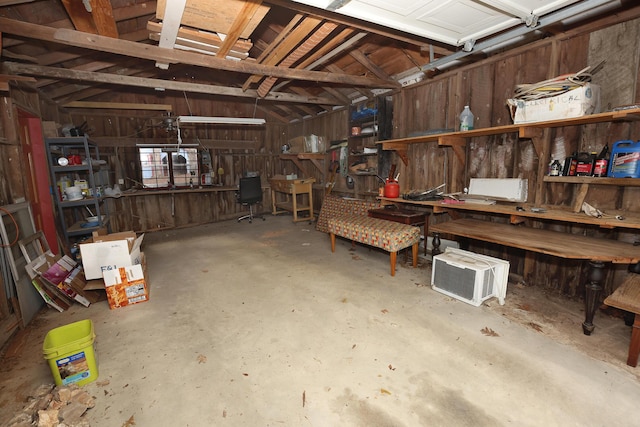 garage with wooden walls and a workshop area