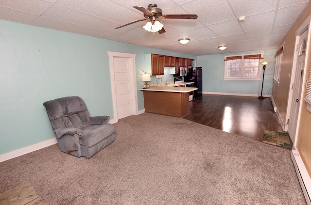 sitting room with sink, a baseboard radiator, ceiling fan, and dark colored carpet