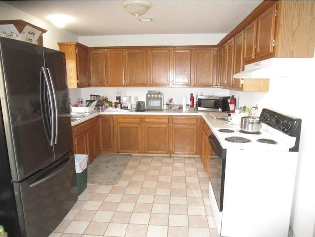 kitchen with electric stove, light tile patterned flooring, and refrigerator