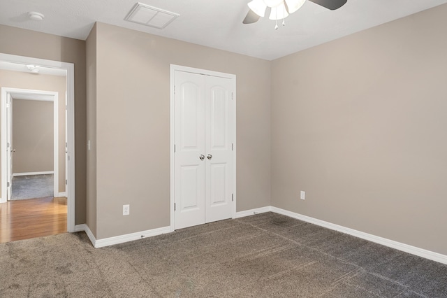 unfurnished bedroom featuring dark carpet, ceiling fan, and a closet