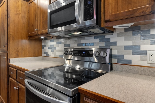 kitchen with stainless steel appliances and decorative backsplash