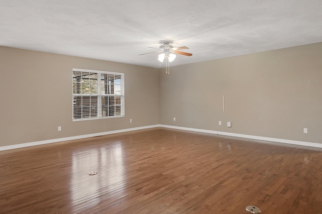 empty room with ceiling fan, dark hardwood / wood-style floors, and a textured ceiling