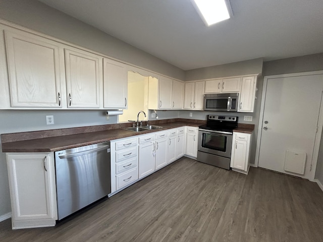 kitchen featuring white cabinetry, stainless steel appliances, dark hardwood / wood-style flooring, and sink