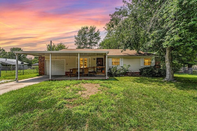 ranch-style home with a carport, a porch, and a lawn