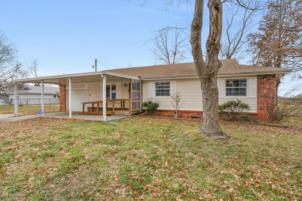 back of house with a carport, a yard, and covered porch