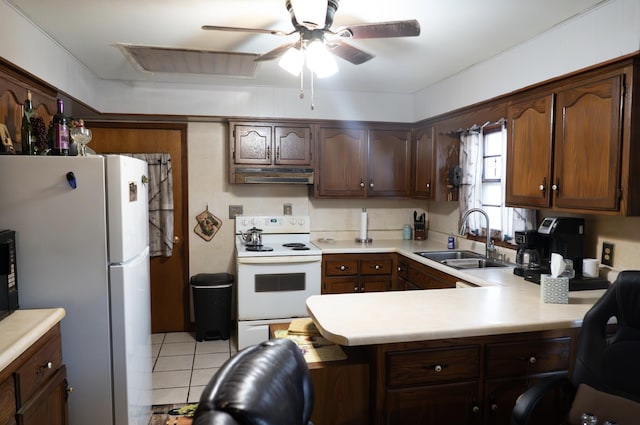 kitchen with sink, white appliances, light tile patterned floors, dark brown cabinetry, and kitchen peninsula