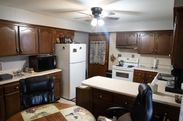 kitchen with dark brown cabinetry, white appliances, built in desk, light tile patterned floors, and ceiling fan