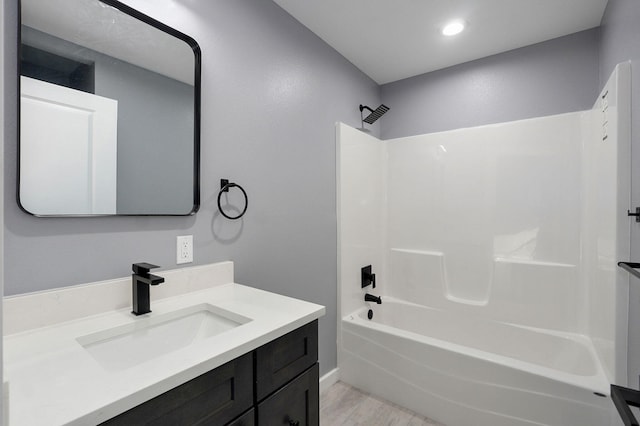 bathroom featuring tub / shower combination, vanity, and wood finished floors