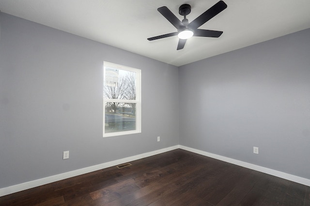 unfurnished room with dark wood-type flooring, baseboards, and visible vents