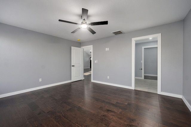 empty room with visible vents, ceiling fan, baseboards, and dark wood-style flooring