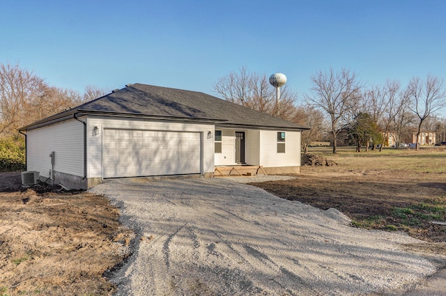 ranch-style home featuring aphalt driveway, cooling unit, and a garage