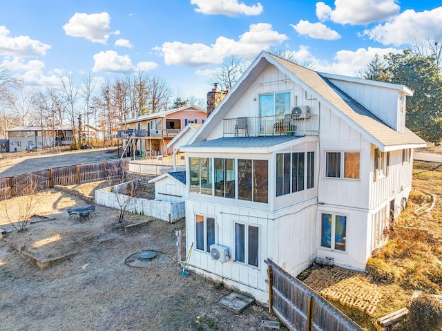 rear view of house featuring a sunroom and a balcony