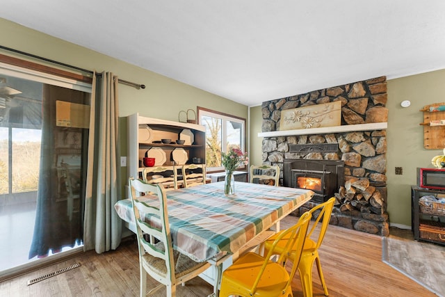 dining room with wood-type flooring and a fireplace