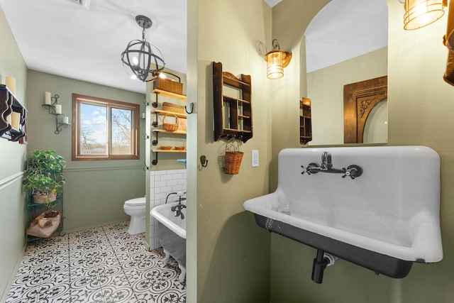 bathroom featuring a washtub, sink, tile patterned flooring, and toilet