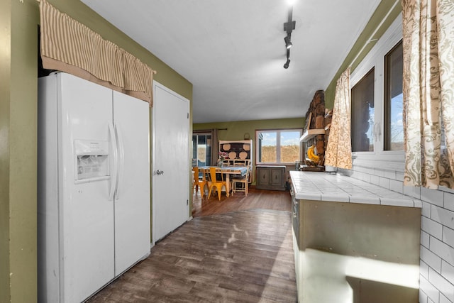 kitchen with dark hardwood / wood-style floors, rail lighting, tile countertops, and white fridge with ice dispenser