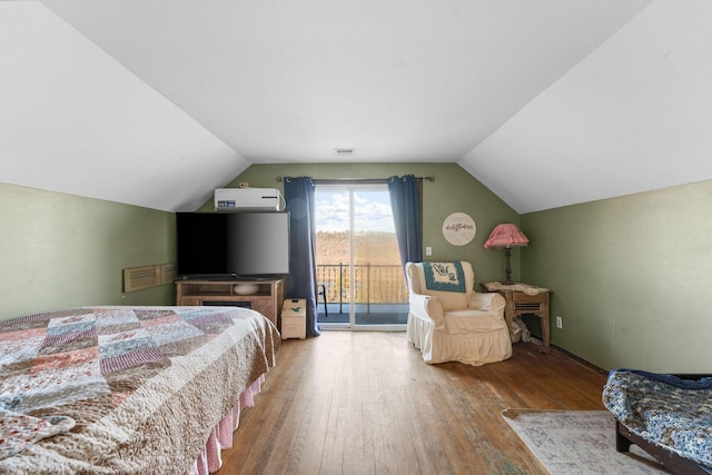 bedroom featuring lofted ceiling, hardwood / wood-style floors, and access to exterior