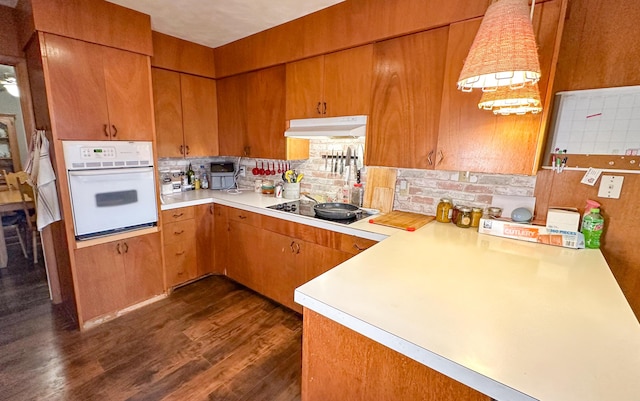 kitchen featuring black electric cooktop, dark hardwood / wood-style flooring, oven, and tasteful backsplash