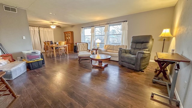 living room with dark hardwood / wood-style flooring and ceiling fan