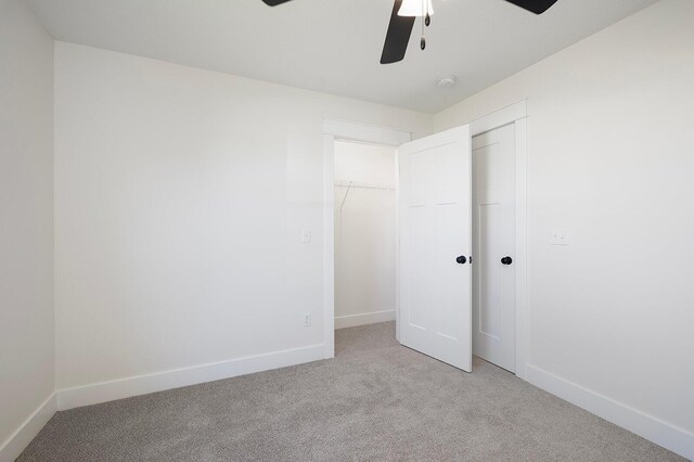 unfurnished bedroom featuring light colored carpet, a closet, and ceiling fan