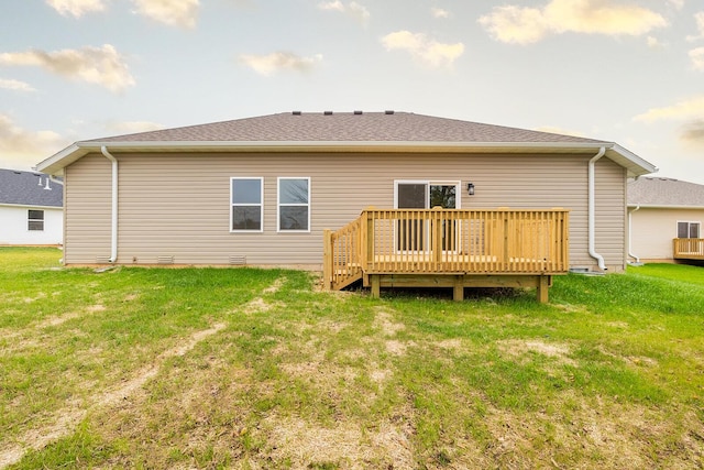 rear view of property featuring a wooden deck and a yard