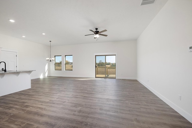 unfurnished living room featuring sink, ceiling fan with notable chandelier, and dark hardwood / wood-style floors