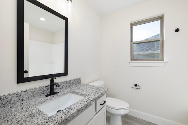 bathroom featuring vanity, wood-type flooring, and toilet