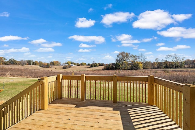 wooden terrace with a rural view and a lawn