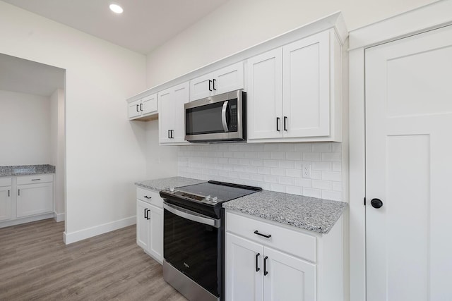 kitchen featuring white cabinetry, light stone countertops, and stainless steel appliances