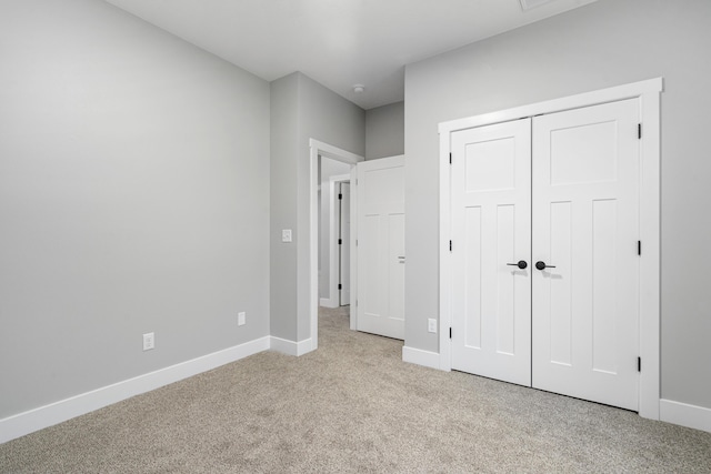 unfurnished bedroom featuring a closet and light carpet