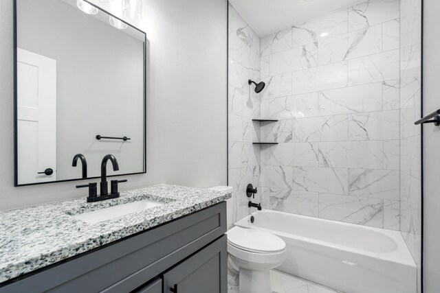 full bathroom featuring tiled shower / bath, vanity, and toilet