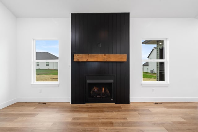 unfurnished living room with a fireplace and light hardwood / wood-style floors